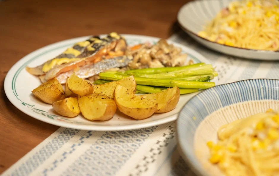 A visually appetizing serving of grilled salmon, roasted potatoes, and asparagus plated with pasta for a gourmet experience.