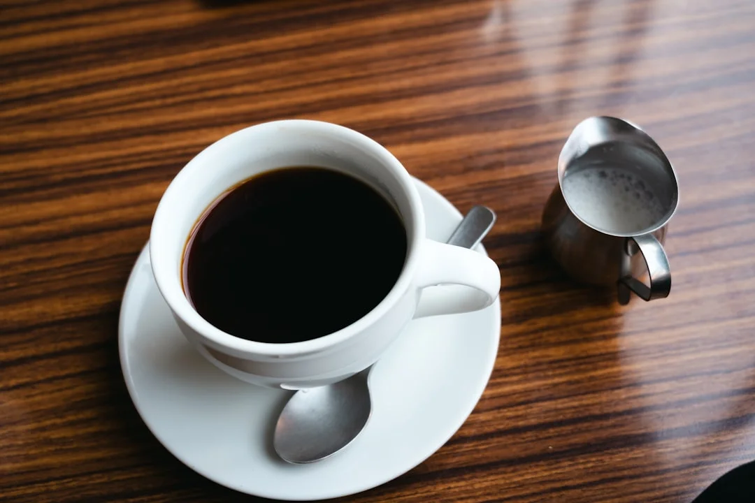 a cup of coffee sitting on top of a wooden table