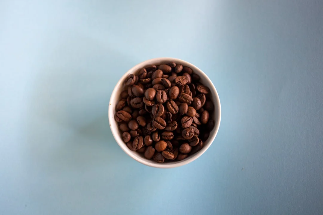 white ceramic mug with coffee beans